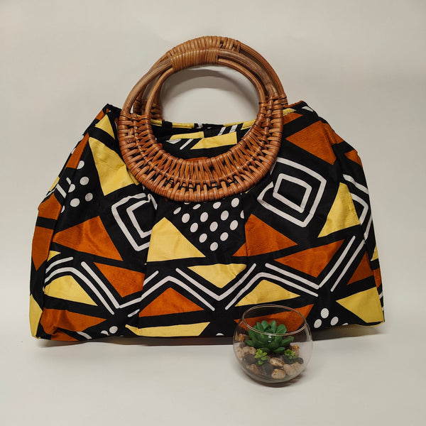 Handbag with geometric pattern and woven handle on a plain background